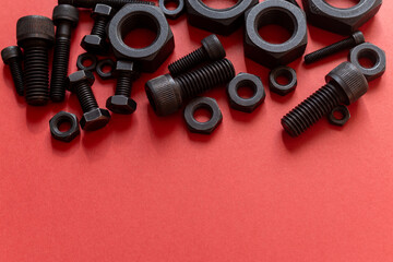 赤背景に並ぶ複数の六角ナットとボルト	