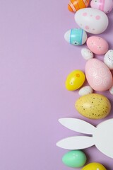 Happy Easter. Colorful eggs, bunny ears on a pastel color background, space for text or advertising