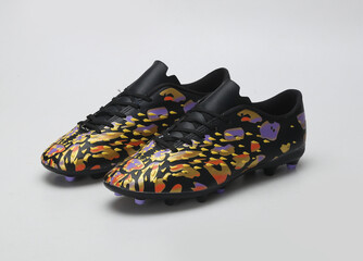 black and golden camouflage design football shoes isolated on light background