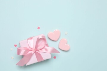 Beautiful gift box with pink hearts on color background