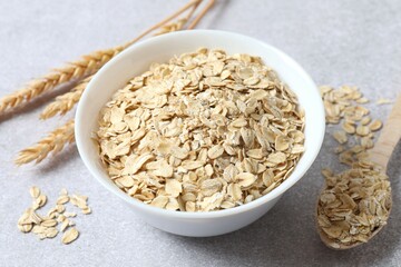 Composition with oatmeal flakes on gray background. Cooking breakfast