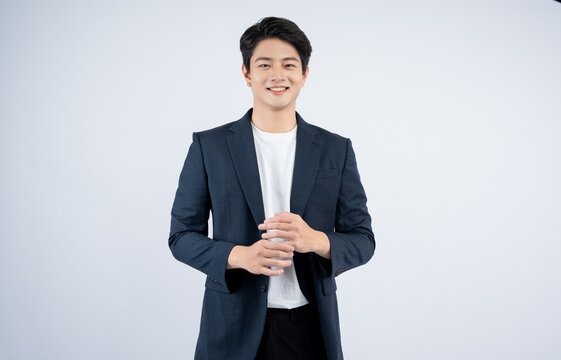 Portrait of young Asian business man posing on white background