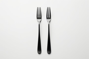 there are two forks and a knife on a white surface