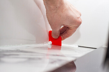 grouting joints with a plastic spatula on porcelain tiles with silicone grout, finishing of rooms...