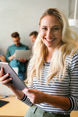 Successful young business woman standing in creative modern office. Success woman concept.