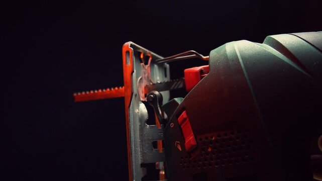 green jigsaw for cutting wood and metal for construction work in red light