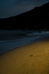 A quiet night scene on the beach of Bình Ba Island, Vietnam. Gentle waves touch the sandy shore,...