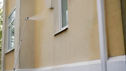 Painting building facade with spray gun