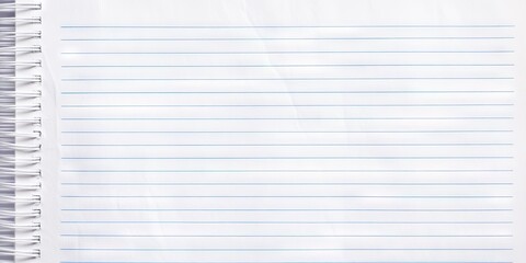 Close up of empty lined notebook paper features blue lines and spiral binding on the left side suitable for writing or drawing activities.