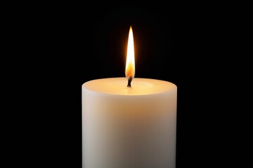 a close up of a lit candle on a black background