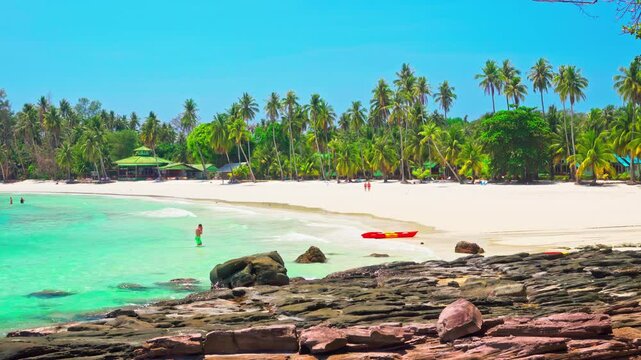 Tropical beach with silhouette travel people on kayak by crystal clear ocean water 4K