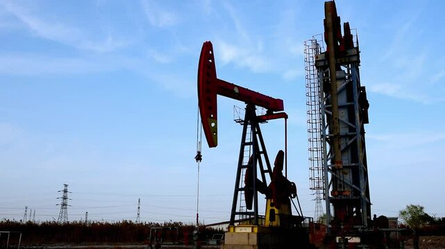 Against the backdrop of blue sky and white clouds, a pumping unit in a certain oil field is producing oil
