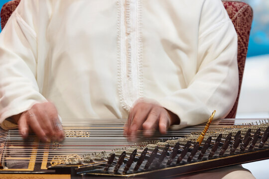 Traditional folk moroccan musician with wooden string instrument. Qanun