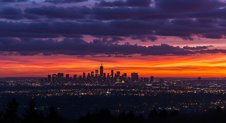 Naklejka premium A breathtaking sunset over a city skyline, with vibrant hues of purple, pink, and orange painting the clouds in a mesmerizing display