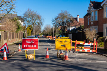 Road closed and diversion sign in an English street in UK suberban residential area., sunny day