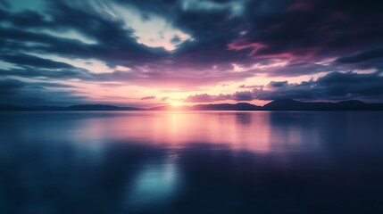 Obraz premium Serene Sunset Over Calm Water Mountainscape