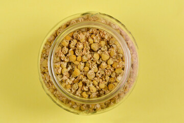 A close-up shot of dried chamomile flowers in a glass jar, highlighting their texture and color