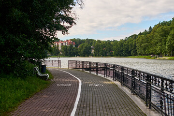 Peaceful lakeside path with benches and lush greenery, ideal for walking and biking, relaxing ambiance