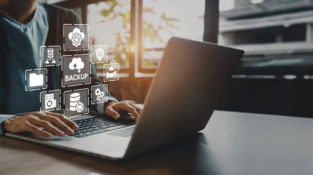 Businessman using a laptop with virtual icons for backup and recovery, Highlights data backup and recovery using cloud backup solutions for disaster recovery