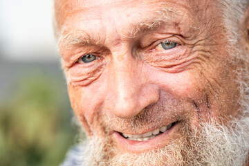 Portrait of an elderly man in retirement, enjoying peaceful moments outdoors, smiling contently, showing physical and mental wellbeing, wearing casual clothes, close-up with wrinkles, gray hair