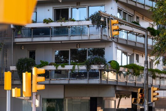 Close-up of yellow traffic lights against a contemporary residential building.