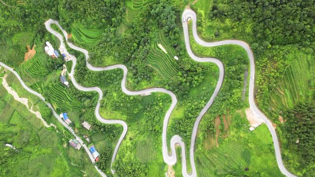 Drone aerial shot of winding mountain road through trees with passing cars and clouds, vietnam. Overcast weather in late summer.
Transfagarasan high mountain road in a cloudy day
