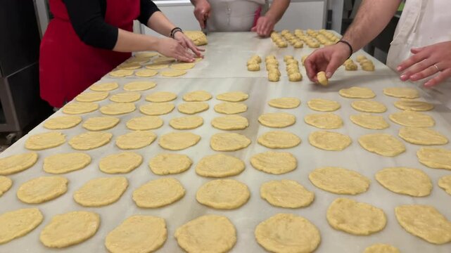 hands of three pastry chef preparing handmade artisanal sweet potato fritters over a marble table in a traditional pastry workshop. 4K