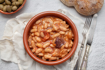 Asturian fabada soup with white beans and blood sausage served in bowl