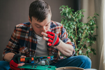Technical professional wearing protective gloves carefully examining electronic circuit board,...