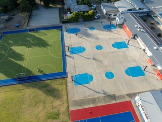 Aerial view of school sports courts. Students play basketball on the concrete courts. Different sports are available. TAKAPUNA, AUCKLAND, NEW ZEALAND