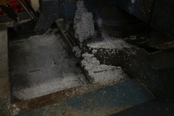 A close-up shot of industrial metalworking, with metal shavings scattered around, showcasing the process of cutting or shaping metal.