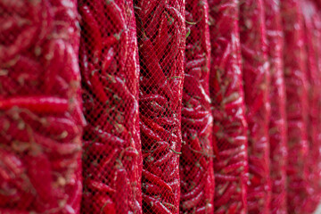 Red hot peppers hanging in mesh bags