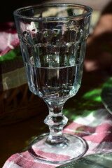 Decorative goblet glass with water on the table in the daylight