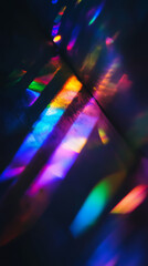 Prismatic light leaks create colorful reflections on dark surface