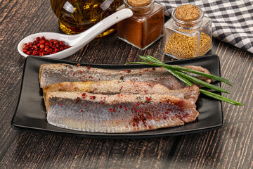 Salted marinated herring fillet with spices