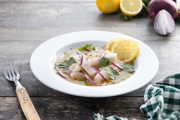 Traditional Peruvian ceviche sea bass fillet on wooden table