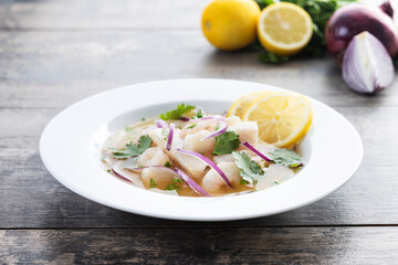 Traditional Peruvian ceviche sea bass fillet on wooden table