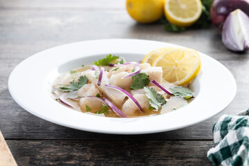 Traditional Peruvian ceviche sea bass fillet on wooden table