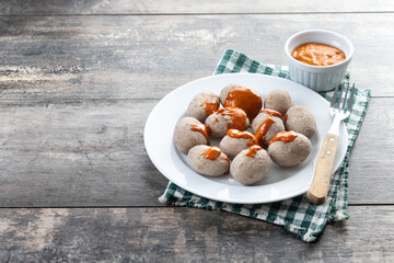 Papas arrugadas with mojo on wooden table. Traditional Canary Islands food. Copy space