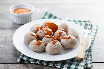 Papas arrugadas with mojo on wooden table. Traditional Canary Islands food.
