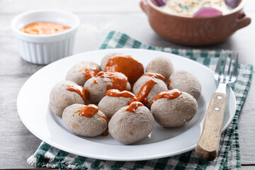 Papas arrugadas with mojo and gofio escaldado on wooden table. Traditional Canary Islands food.