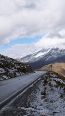 Vertical image of Ruta 107 on the way to Tunel Punta Olimpica with Cordillera Blanca snow capped mountain range in the background. Location:  East-central region of Ancash of Peru