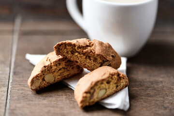 Cantuccini (Italian cookie) and a cup of coffee on dark wooden background. Close up.