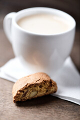 Cantuccini (Italian cookie) and a cup of coffee on dark wooden background. Close up.