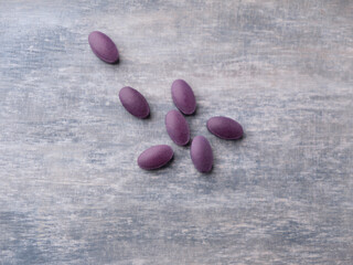 Lutein tablets. Dietary supplement on wooden background. Soft focus. Top view. Close up. Copy space