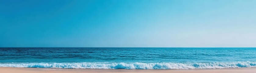 Fototapeta premium A serene landscape of gentle blue ocean waves softly lapping against a pristine sandy beach, under a clear sky, evoking tranquility and relaxation