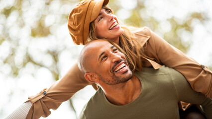 stylish couple enjoying a spontaneous piggyback ride outdoors