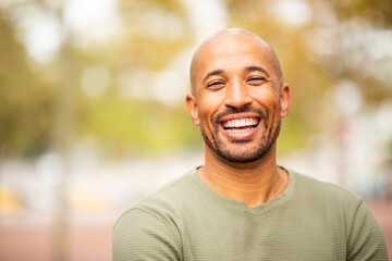 Close up bearded and bald man laughing outdoors