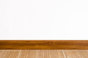Clean wall with brown baseboard and tiled floor.