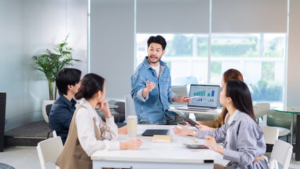Fototapeta premium Engaging business meeting with presenter discussing data analysis and charts. Team collaboration in modern office setting. Leader Teamwork stratup
